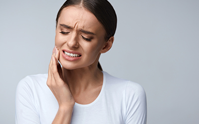 A woman holding her jaw in pain
