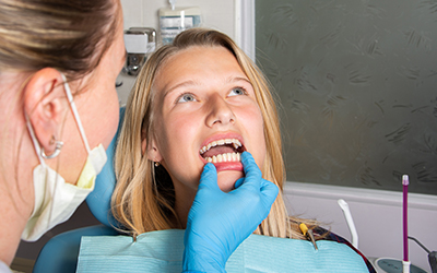 A woman having her teeth looked at by a dentist