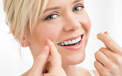 A woman flossing her teeth