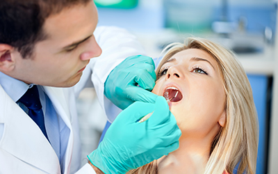 A woman having her teeth looked at by a dentist. 