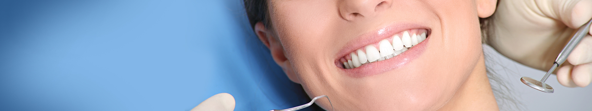Cropped image of woman's smile receiving dental cleaning and exam