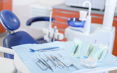 Dental tools on a tray beside the dental chair