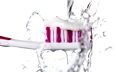 Toothbrush with toothpaste under running water