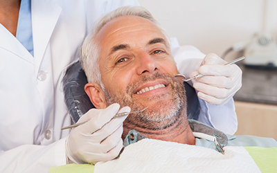 An older man having his teeth examined by the dentist